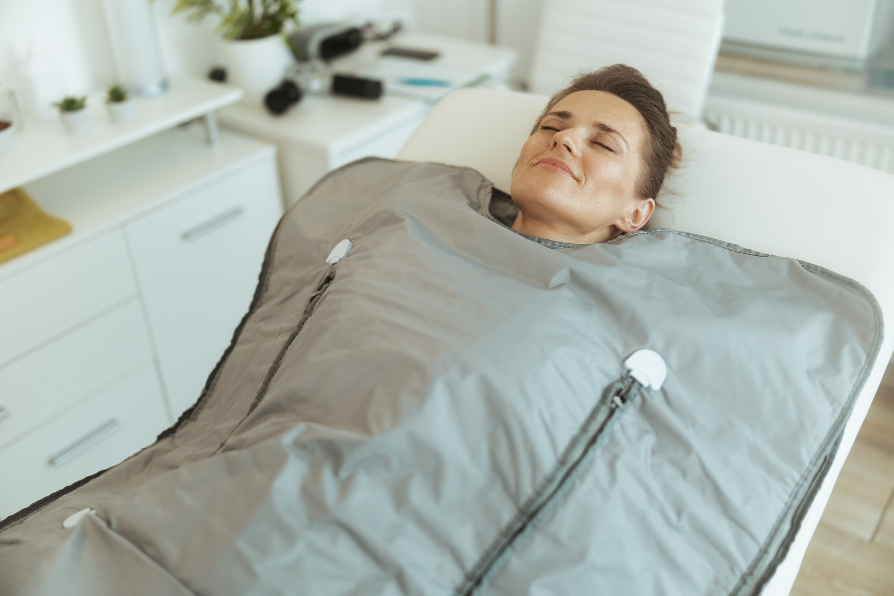 woman doing whiskey swaddling procedure in thermal blanket